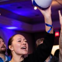 Grads cheer and raise hands with beach ball
